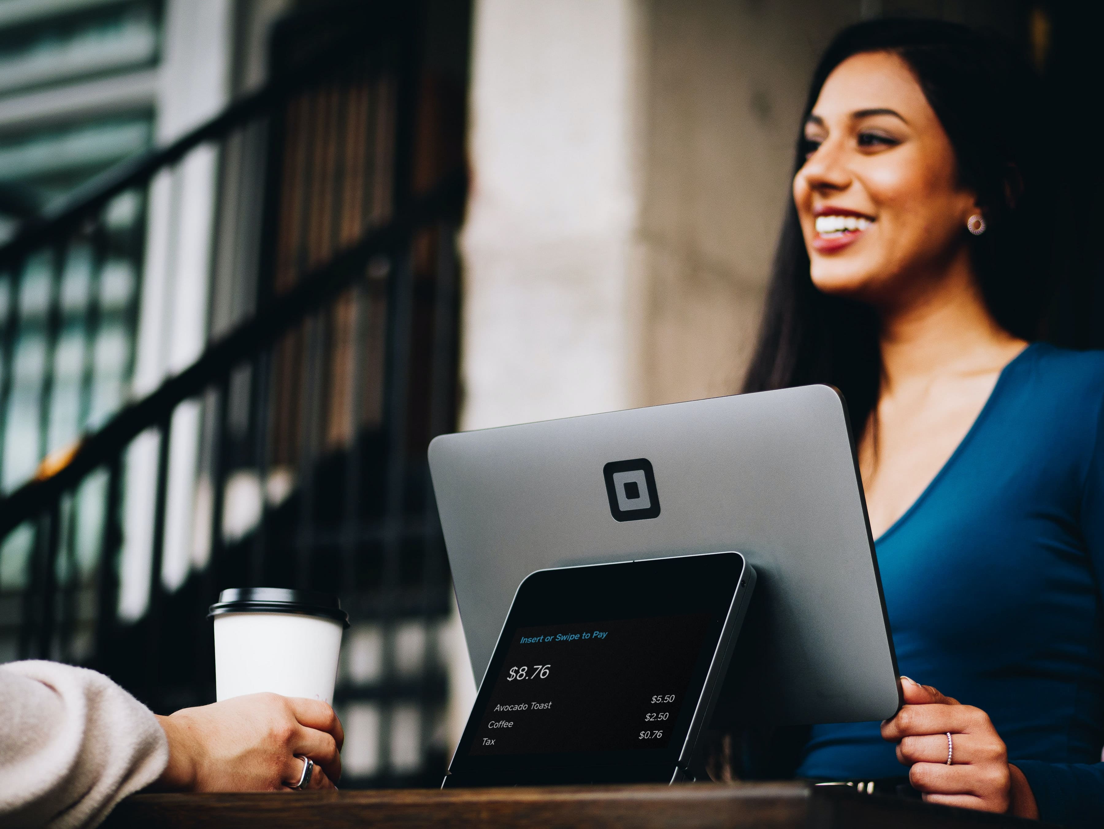 Woman standing behind a point of sale system at a small business